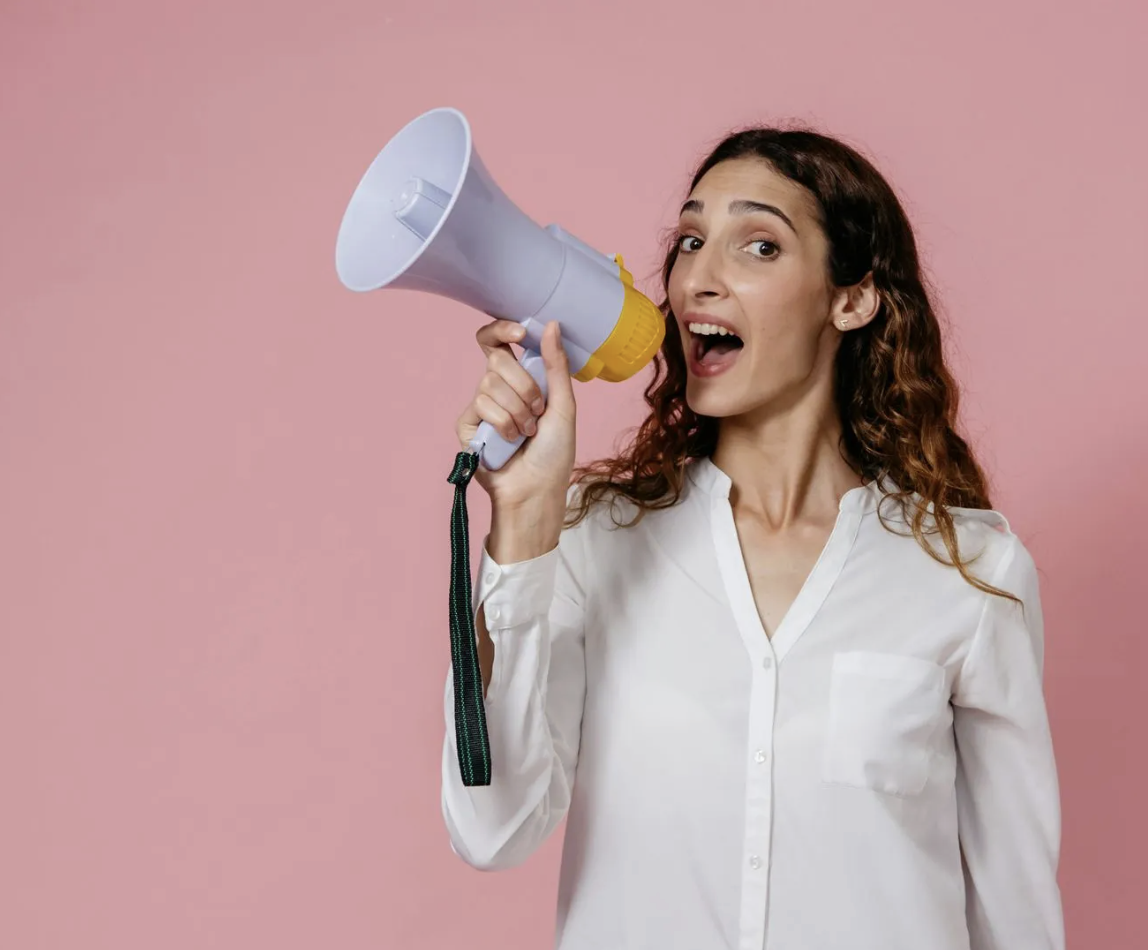 Enthusiastic woman using a megaphone, promoting web design services.